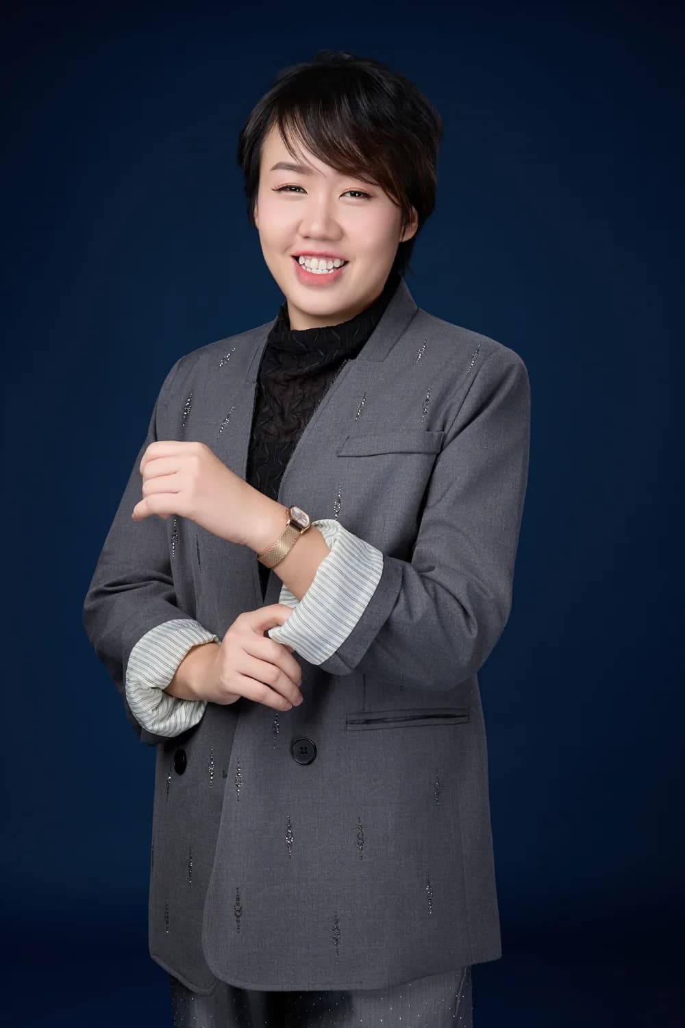 Vivien Lim in a grey suit against a blue backdrop